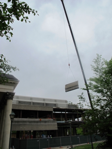 Wide shot of crane lifting the concrete block up and away