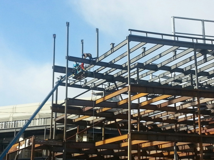 Close up of crew at work on steel framing extension along Queen's Park