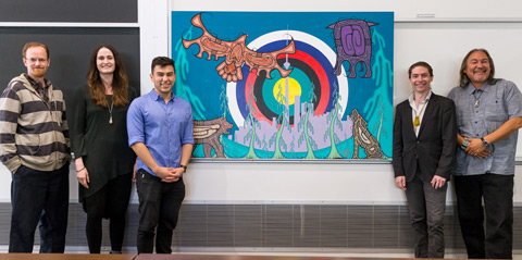 2016-17 Members of the Indigenous Law Students' Association (L-R) Douglas Varrette, Natalie Day, Joshua Favel and Zachary Biech stand with Artist Jay Bell Redbird and his new painting