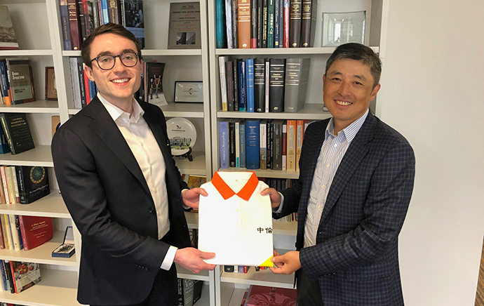 Law student James Flynn receives a gift of a Zhong Lun Law Firm golf shirt, ahead of his placement in Shanghai this summer, from alumnus and award donor, Scott Guan, SJD 2003.