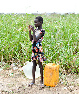 A girl stands near a line for clean water at a UN camp near Bentiu, South Sudan