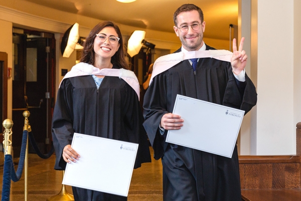 Two law grads in Con Hall who picked up their degrees