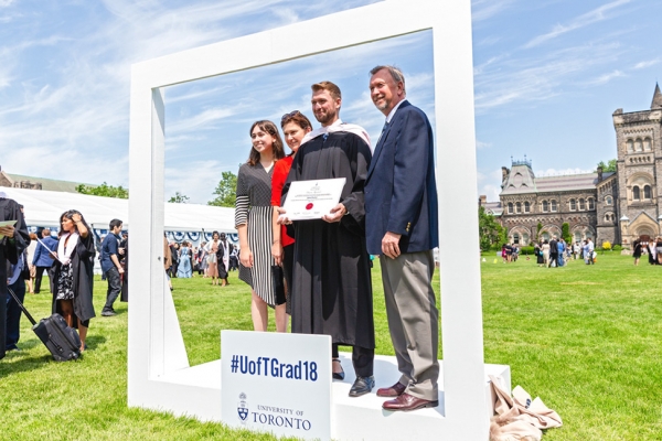 Law grad with family in the Instagram frame by Convocation Plaza