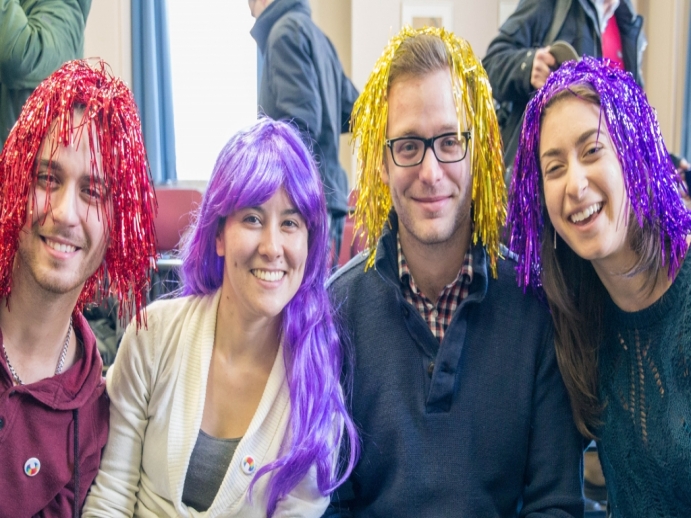 Group of 4 students laughing, wearing outrageous wigs