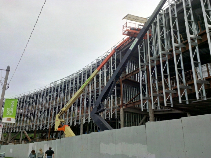 Cranes working on the Queen's Park facade of the Jackman Law building, inserting fins for new windows 