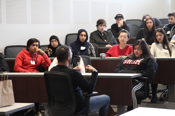 Diverse students from See Yourself Here in the Moot Court Room talking to a law staff person