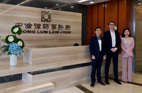 Law student with two Chinese associates in front of Shanghai law firm reception