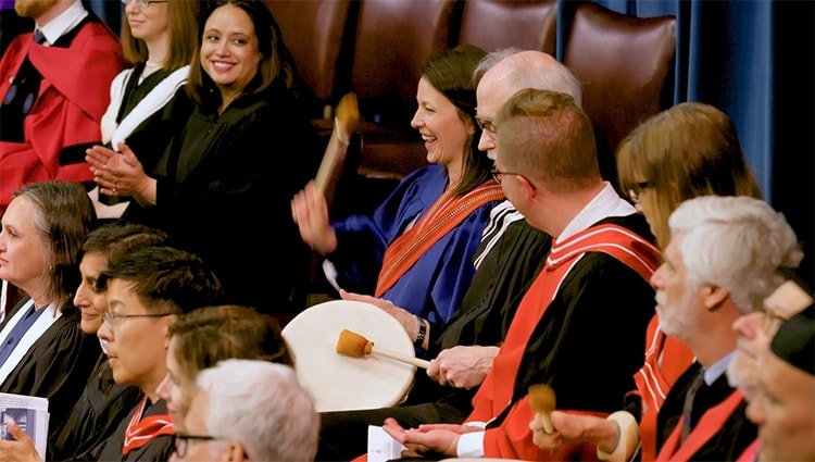 Amanda Carling, pictured centre, beats a drum to honour Indigenous grads at U of T's spring convocation (photo by Johnny Guatto)