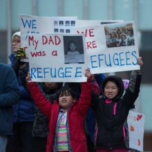 children with pro-refugee signs at a protest