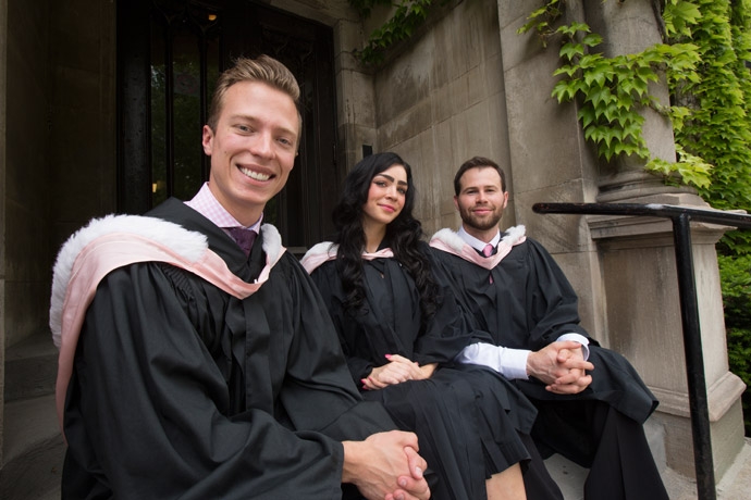 Three students sitting on steps of law building