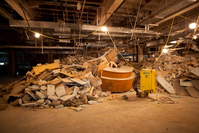 Demolition site showing piles of rubble, old desks from the library
