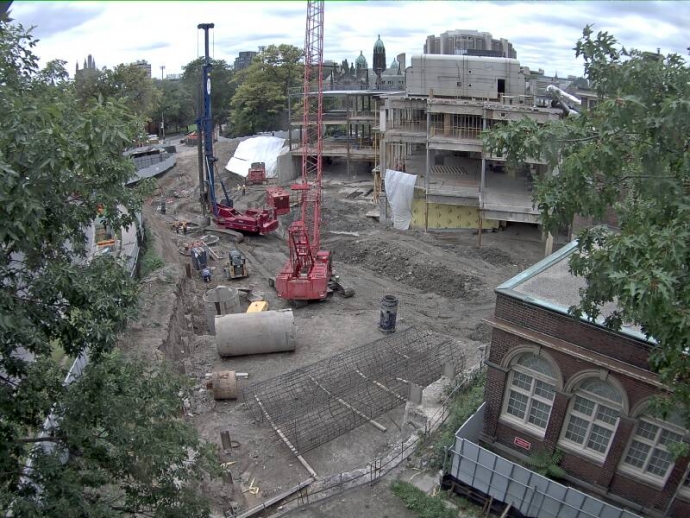 Large caisson driller and crane on site with caisson sleeves to be inserted