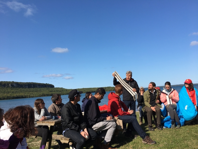 Law students attend the Indigenous Law in Context course at Cape Croker reserve, here sitting by Georgian Bay as faculty teach