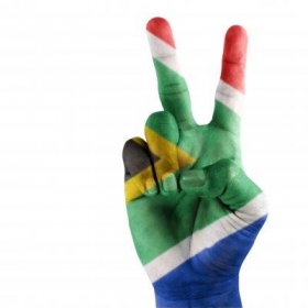 South African flag painted on a hand depicting the V for victory sign