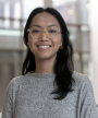 Yukiko, wearing a grey sweater, smiles in a photograph taken in the Jackman Law Building